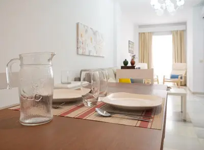 a dining room table with plates and glasses on it at Sibs Sanlucar-San Juan-Cabildo Centro Playa Familias Amigos in Sanlúcar de Barrameda