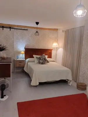a bedroom with a bed and a red rug at La casa de loto in Alcalá de los Gazules