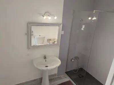 a white bathroom with a sink and a shower at La casa de loto in Alcalá de los Gazules