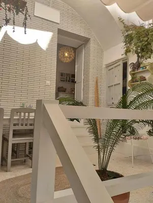 a porch with a fence and a table and a plant at La casa de loto in Alcalá de los Gazules