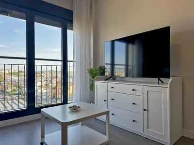 a living room with a tv and a white dresser at Apartamento Alazán - Ole Solutions in Jerez de la Frontera