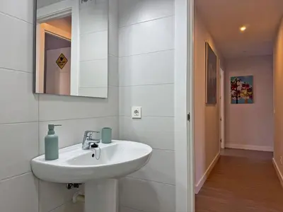 a white bathroom with a sink and a mirror at Apartamento Alazán - Ole Solutions in Jerez de la Frontera
