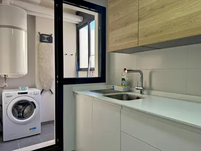 a kitchen with a washing machine and a sink at Apartamento Alazán - Ole Solutions in Jerez de la Frontera