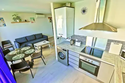 a small kitchen with a table and a dining room at Oceanfront Duplex with a Rooftop Pool and Terrace in El Puerto de Santa María