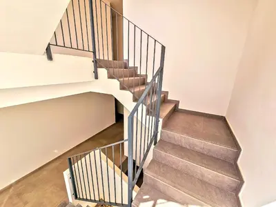 a staircase in a home with white walls and wood floors at Oceanfront Duplex with a Rooftop Pool and Terrace in El Puerto de Santa María