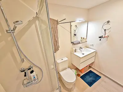 a bathroom with a shower and a toilet and a sink at Oceanfront Duplex with a Rooftop Pool and Terrace in El Puerto de Santa María