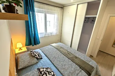 a small bedroom with a bed and a window at Oceanfront Duplex with a Rooftop Pool and Terrace in El Puerto de Santa María