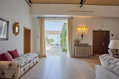 a living room with a couch and a large sliding glass door at Finca La Fuensanta in Arcos de la Frontera