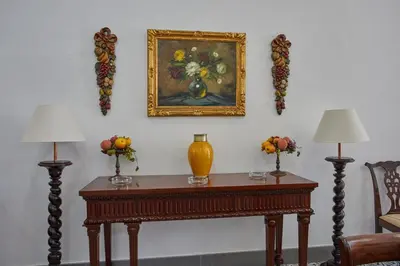 a table with two lamps and a painting on the wall at Finca La Fuensanta in Arcos de la Frontera