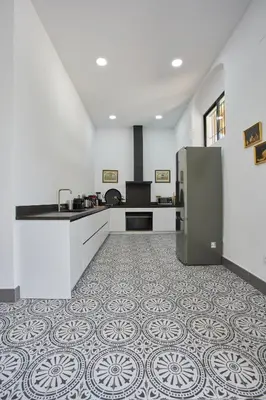 a kitchen with a stainless steel refrigerator and a tile floor at Finca La Fuensanta in Arcos de la Frontera
