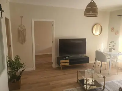 a living room with a flat screen tv and a table at Apartamento Juan Belmonte in Jerez de la Frontera