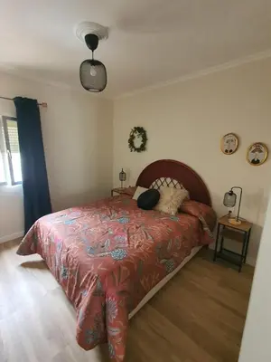 a bedroom with a bed with a red comforter at Apartamento Juan Belmonte in Jerez de la Frontera