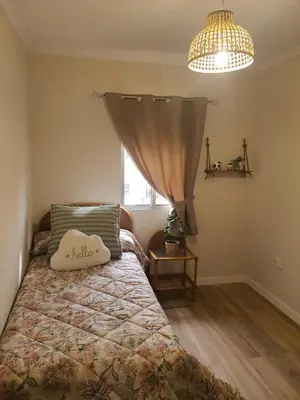 a bedroom with a bed with a pillow and a window at Apartamento Juan Belmonte in Jerez de la Frontera