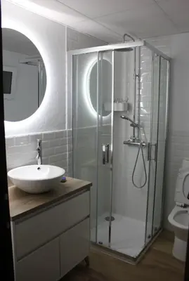 a bathroom with a glass shower and a sink at Orchard View in Campano