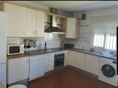 a kitchen with white cabinets and a microwave at Orchard View in Campano