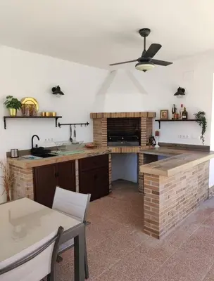 a kitchen with a table and a ceiling fan at Orchard View in Campano