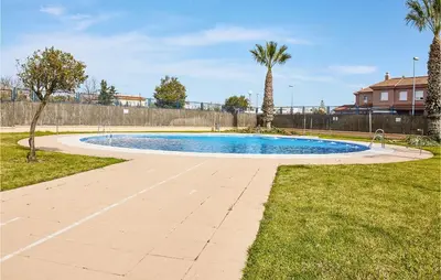 a swimming pool in a yard with palm trees at Pet Friendly Apartment in Sanlúcar de Barrameda