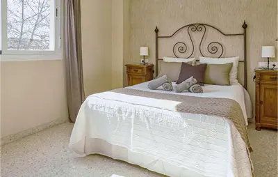 a bedroom with a large white bed with two night stands at Pet Friendly Apartment in Sanlúcar de Barrameda