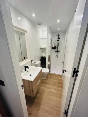 a white bathroom with a sink and a toilet at Apartamento Arsenio Beach in Cádiz