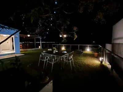 a patio with a table and chairs at night at Casa de invitados, a pie de playa, en La Torre Verde in El Puerto de Santa María