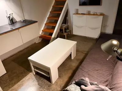 a living room with a white bench and a staircase at Casa de invitados, a pie de playa, en La Torre Verde in El Puerto de Santa María