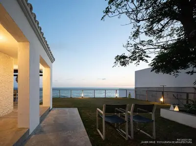 a patio with a table and chairs and the ocean at Casa de invitados, a pie de playa, en La Torre Verde in El Puerto de Santa María