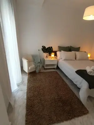 a bedroom with a large bed and a rug at Casa Palacio Arcos del Carmen in Jerez de la Frontera