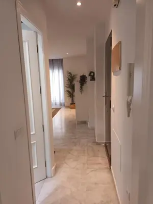 a hallway of an apartment with white walls and tile floors at Casa Palacio Arcos del Carmen in Jerez de la Frontera