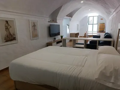 a bedroom with a large white bed in a room at La Bodeguita in Jerez de la Frontera