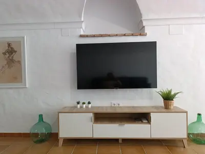 a living room with a television on a white wall at La Bodeguita in Jerez de la Frontera
