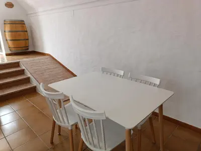 a white table and chairs in a room with stairs at La Bodeguita in Jerez de la Frontera