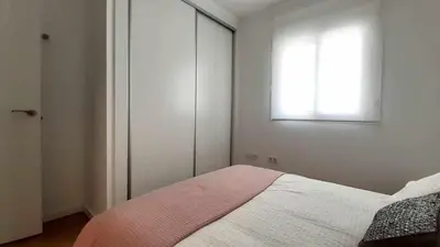 a white bedroom with a bed and a window at Casa Carivid - en el centro y con parking gratis - in Sanlúcar de Barrameda