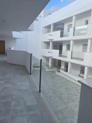 a large white building with a staircase in front of it at Casa Carivid - en el centro y con parking gratis - in Sanlúcar de Barrameda