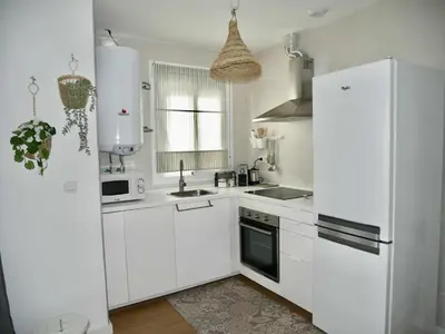 a kitchen with white cabinets and a white refrigerator at Casa Carivid - en el centro y con parking gratis - in Sanlúcar de Barrameda