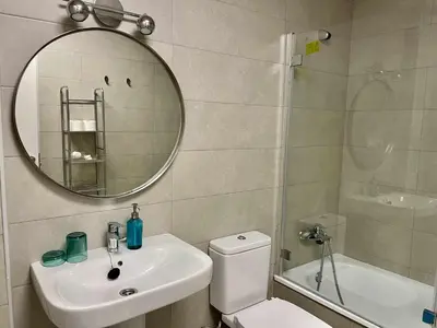 a bathroom with a toilet and a sink and a mirror at Casa Carivid - en el centro y con parking gratis - in Sanlúcar de Barrameda