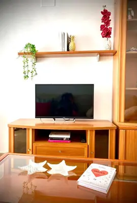 a living room with a tv and a glass table at MyChoice Aitana in Rota