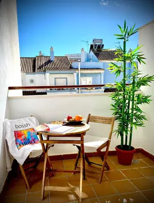 a table and chairs on a balcony with a plant at MyChoice Aitana in Rota