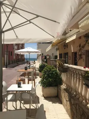 a group of tables and umbrellas on a patio at Hotel Macavi Playa in Rota