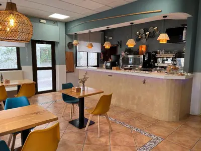 a restaurant with a counter and tables and chairs at Hotel Macavi Playa in Rota