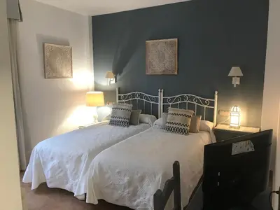 a bedroom with a large white bed with two pillows at Hotel Macavi Playa in Rota
