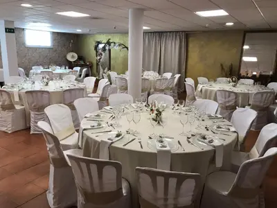 a room full of tables and chairs with white tablecloths at Hotel Macavi Playa in Rota