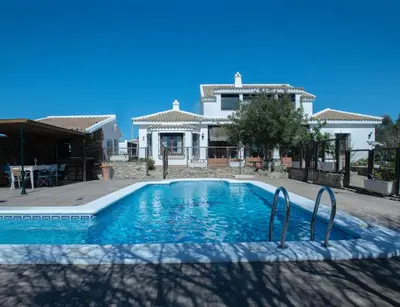 a villa with a swimming pool in front of a house at Villa Encanto in Conil de la Frontera