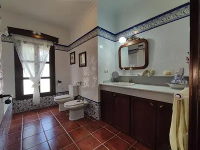 a bathroom with a toilet and a sink and a mirror at Villa Encanto in Conil de la Frontera