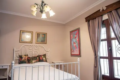 a bedroom with a white bed and a chandelier at Villa Encanto in Conil de la Frontera