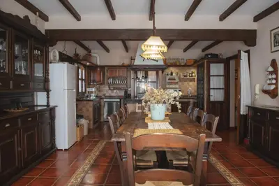 a kitchen with a table with chairs and a refrigerator at Villa Encanto in Conil de la Frontera