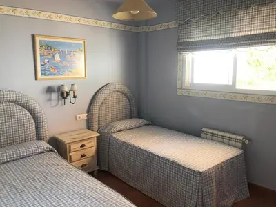 two twin beds in a bedroom with a window at Villa Bosque Novo Sancti petri Grupo AC Gestión in Chiclana de la Frontera