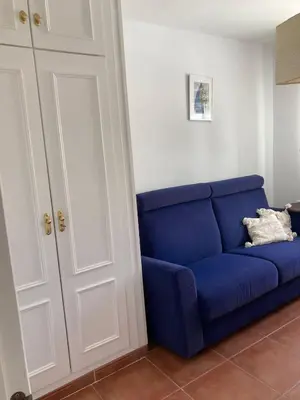 a blue couch sitting next to a white door at Villa Bosque Novo Sancti petri Grupo AC Gestión in Chiclana de la Frontera