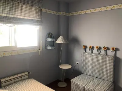 a bedroom with two beds and a lamp and a window at Villa Bosque Novo Sancti petri Grupo AC Gestión in Chiclana de la Frontera