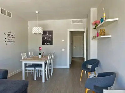 a dining room and living room with a table and chairs at Apartamento Sheris - Ole Solutions in Jerez de la Frontera