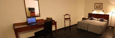a bedroom with a desk with a laptop and a bed at Hotel Caribe in Rota